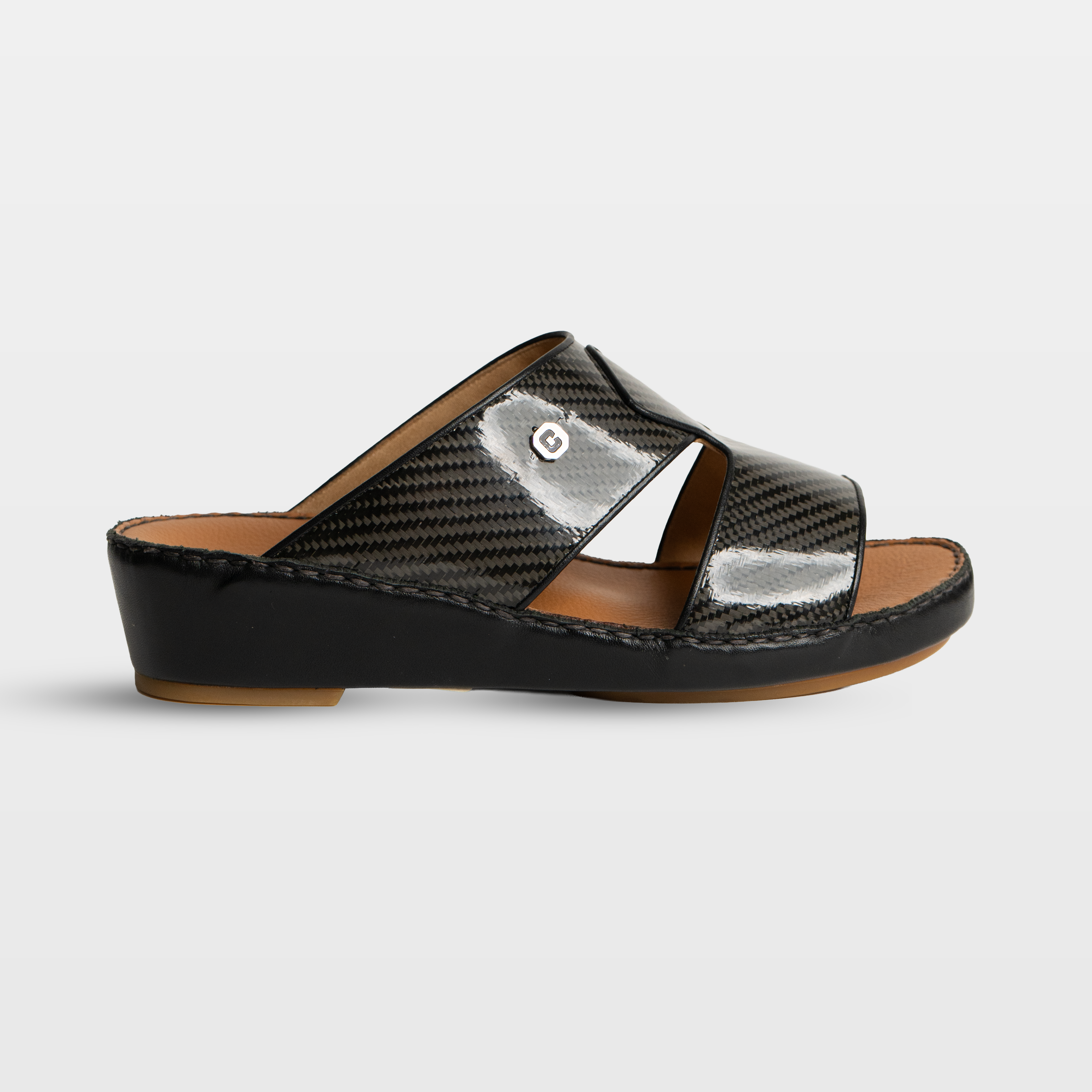 Black sandal with a metallic finish on a light gray background