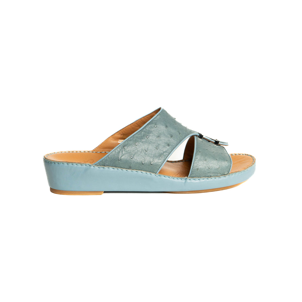 Light blue sandal with a brown sole on a white background