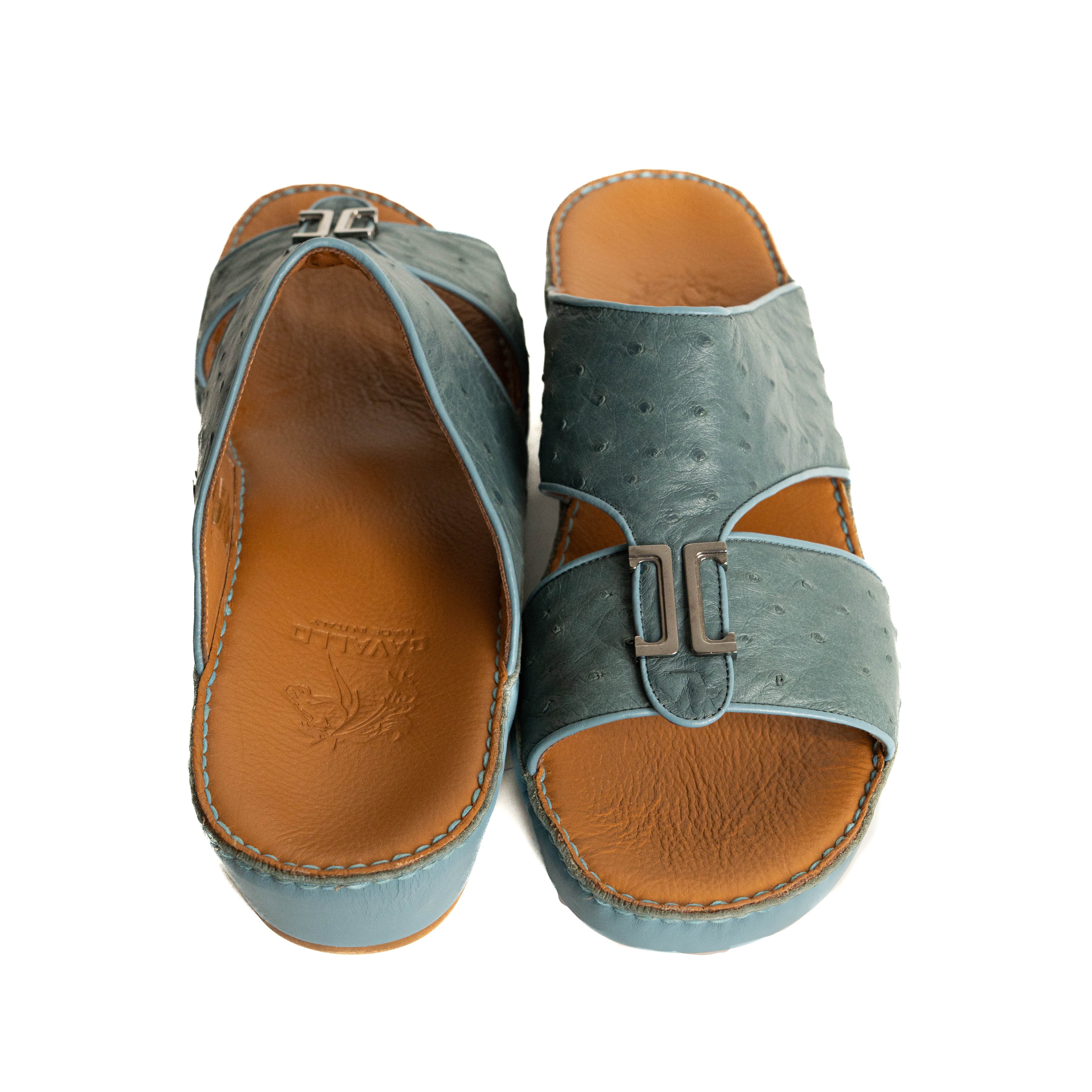 Pair of sandals with blue uppers and brown soles on a white background