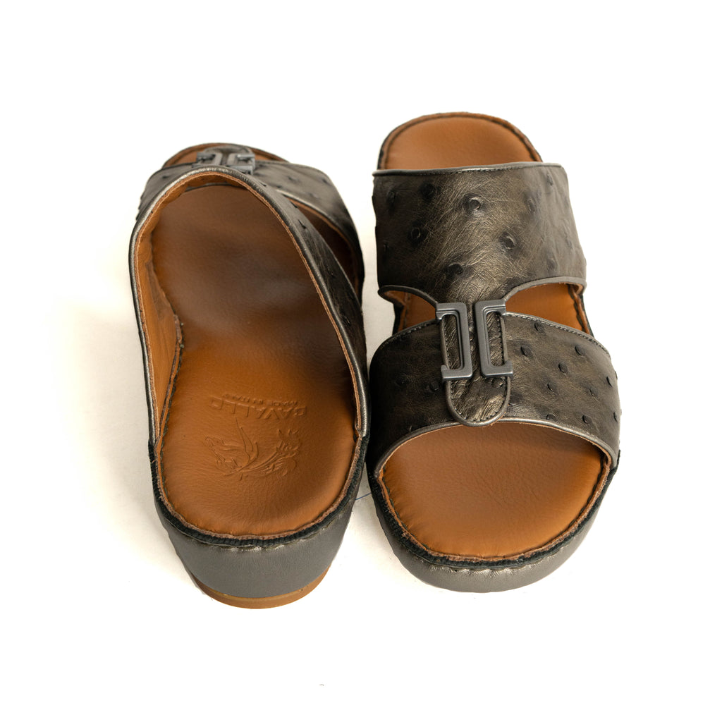 Pair of brown sandals with a buckle on a white background