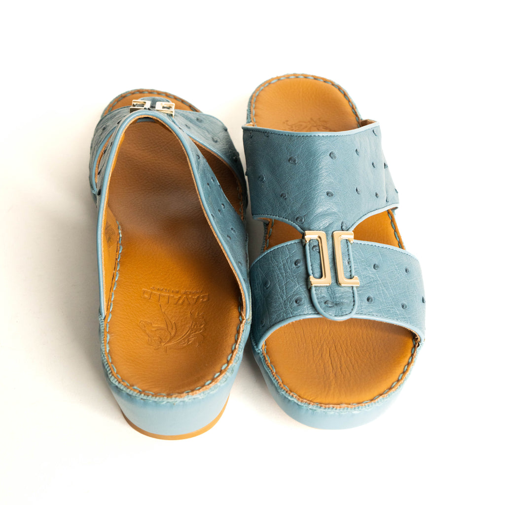 Pair of blue sandals with brown soles on a white background