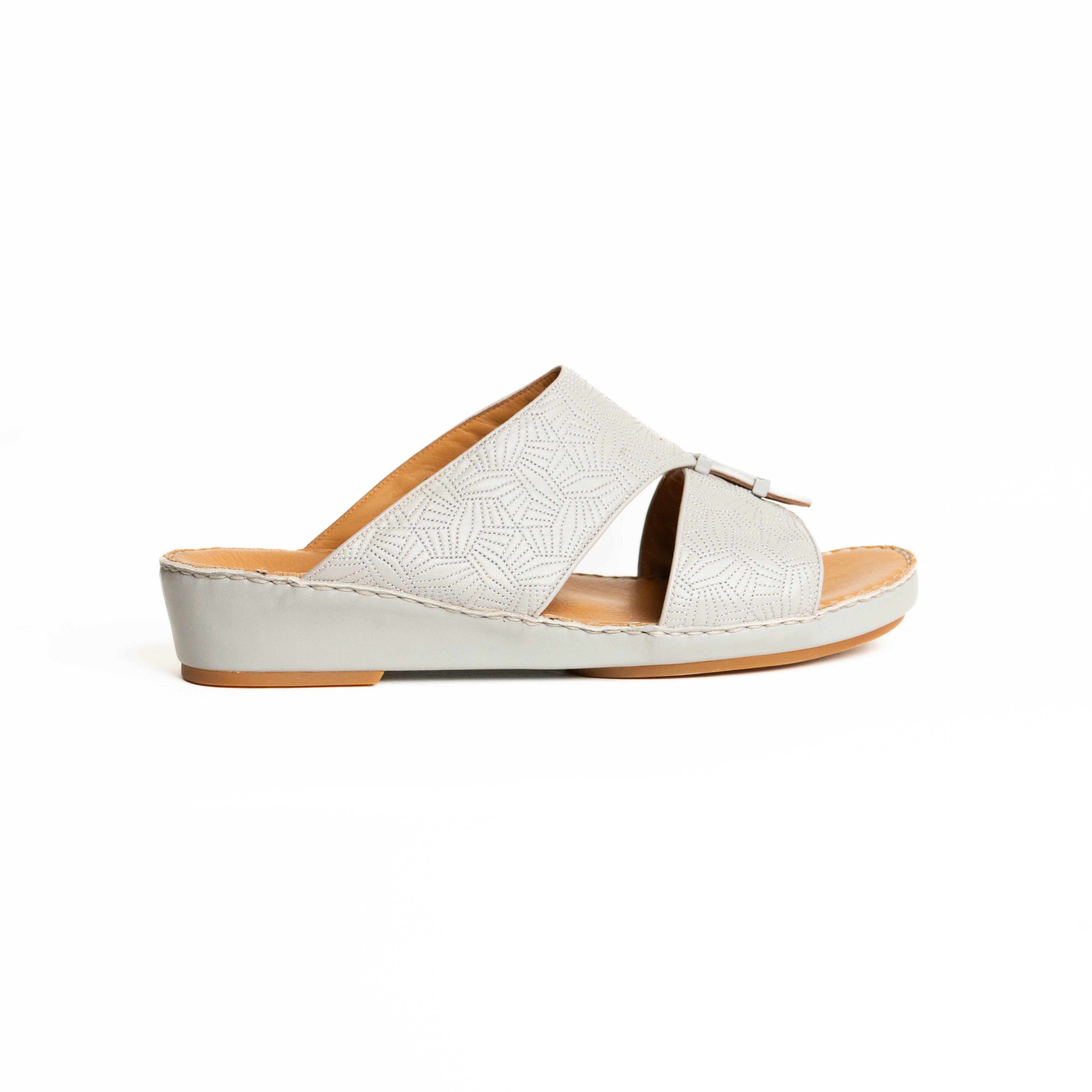 White sandal with brown sole on a white background