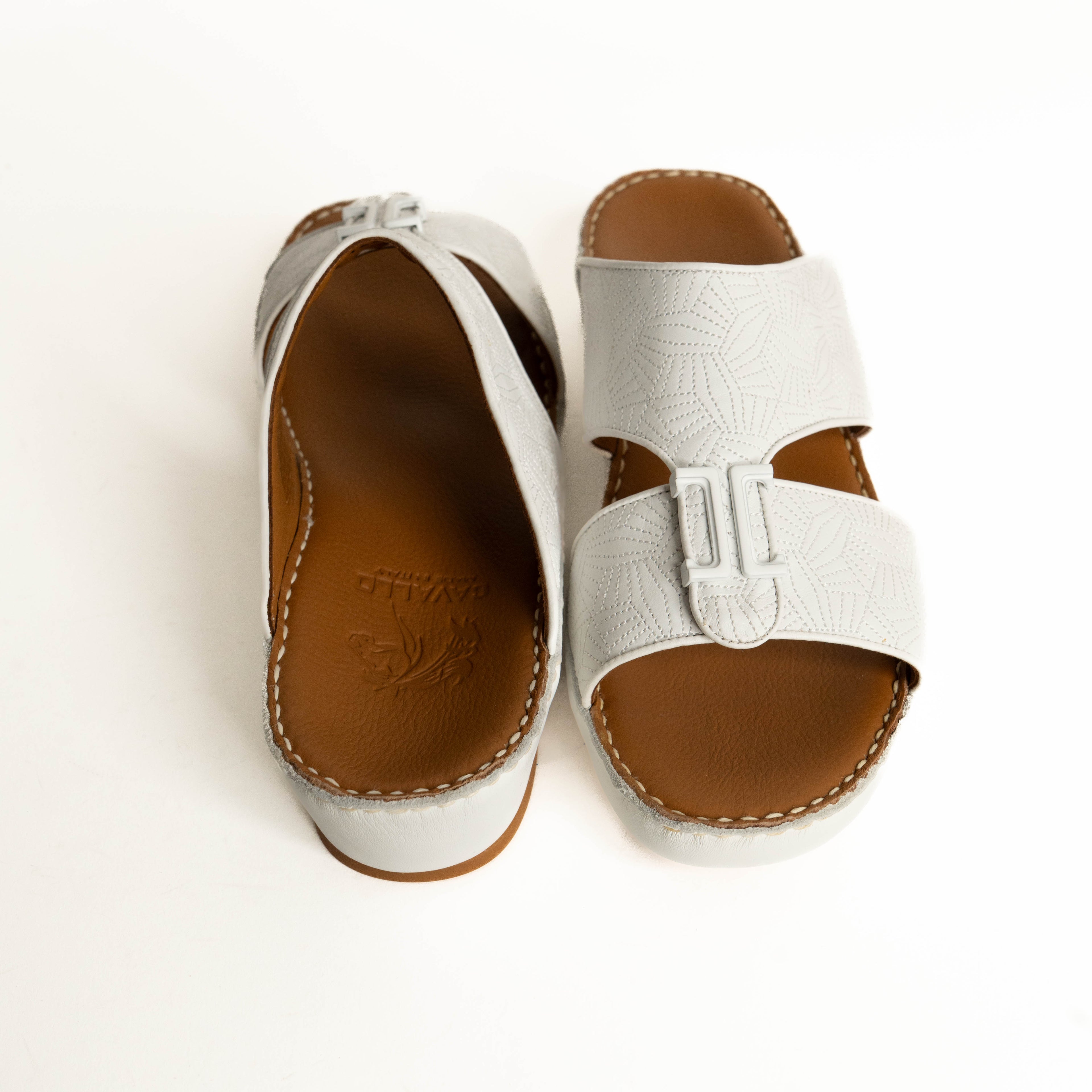 White sandals with brown soles on a white background
