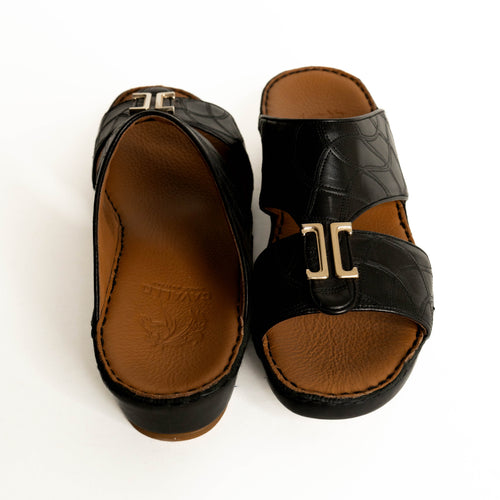Pair of black sandals with brown soles on a white background
