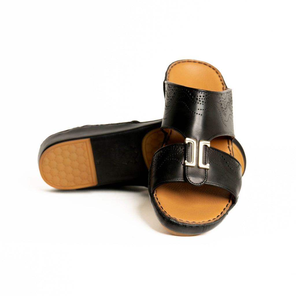 Black sandals with tan soles on a white background