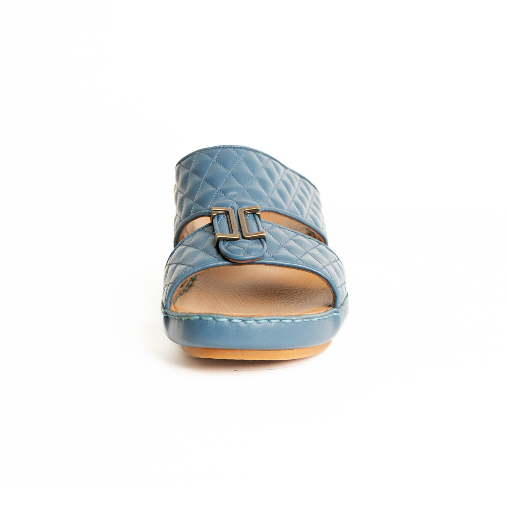 Blue quilted sandal with a buckle on a white background