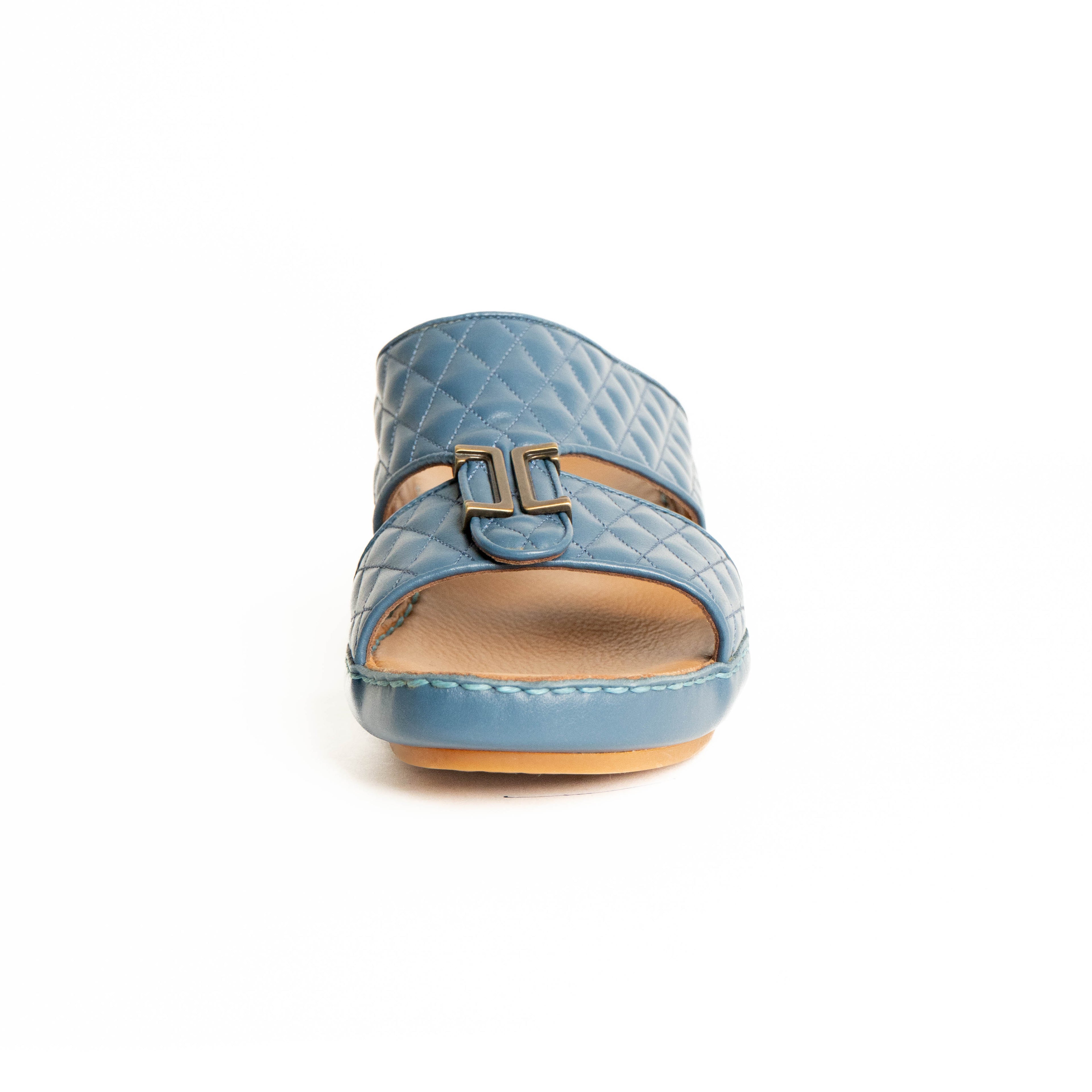 Blue quilted sandal with a buckle on a white background
