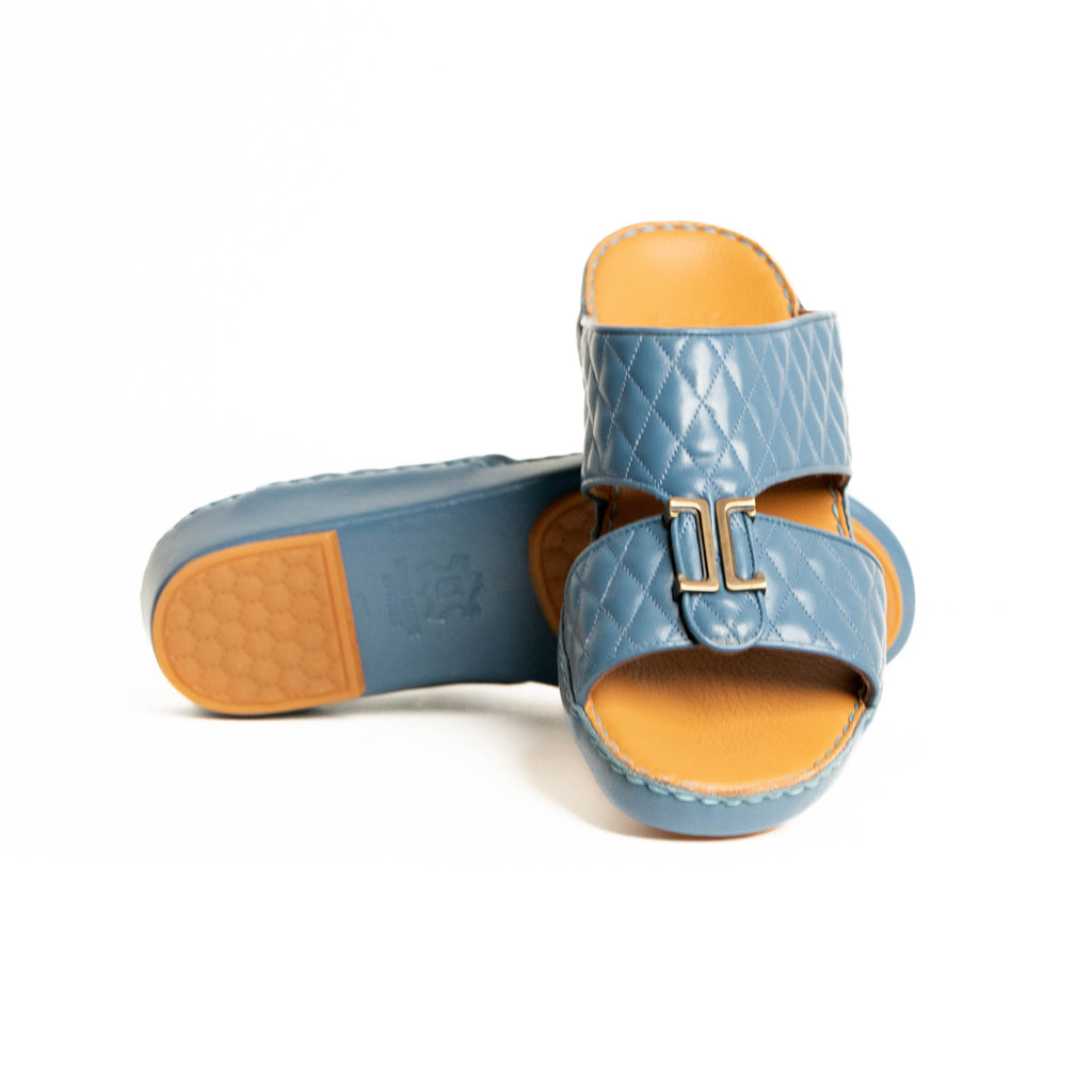 Pair of blue sandals with tan soles on a white background