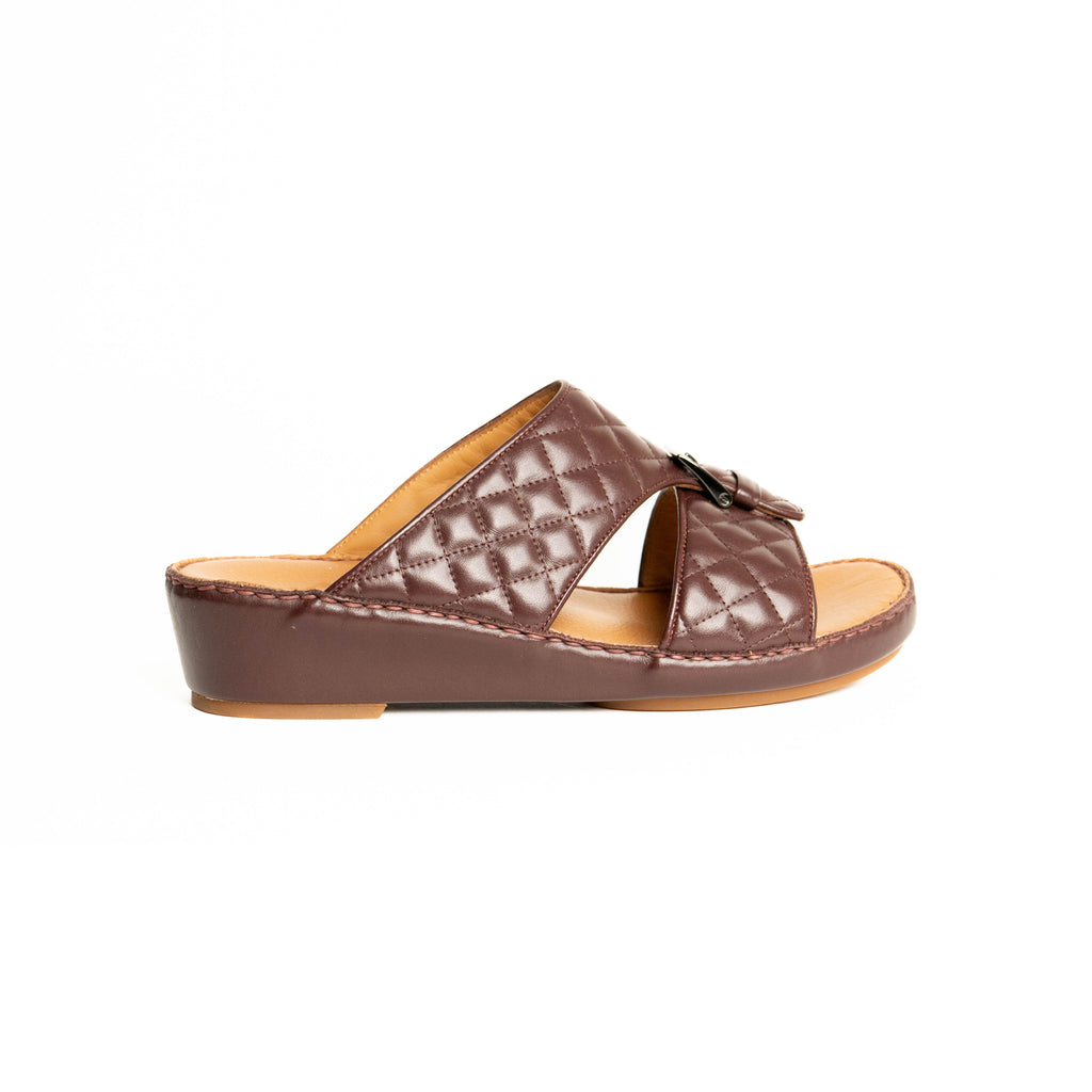 Brown sandal with quilted pattern on a white background
