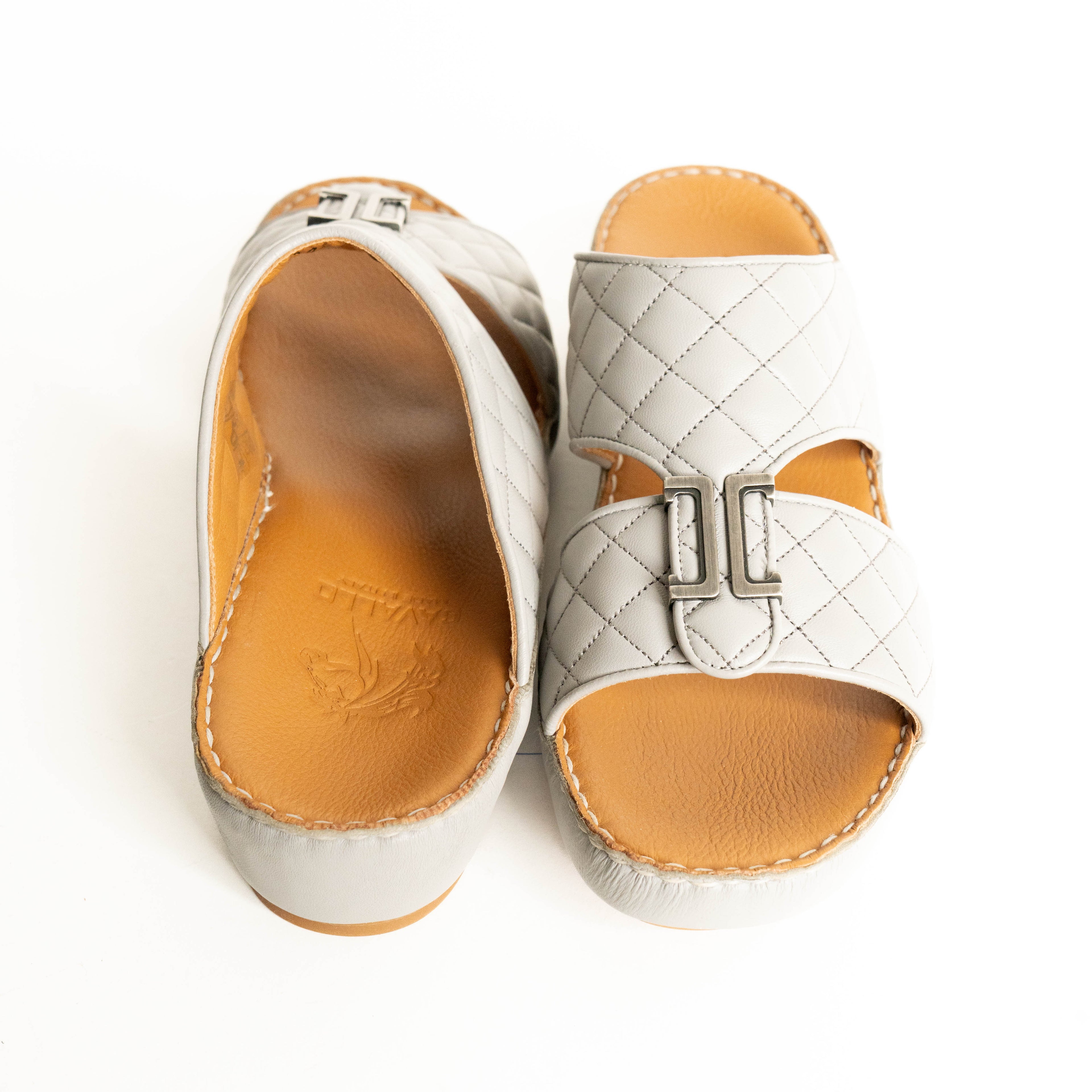 White quilted sandal with tan insole on a white background