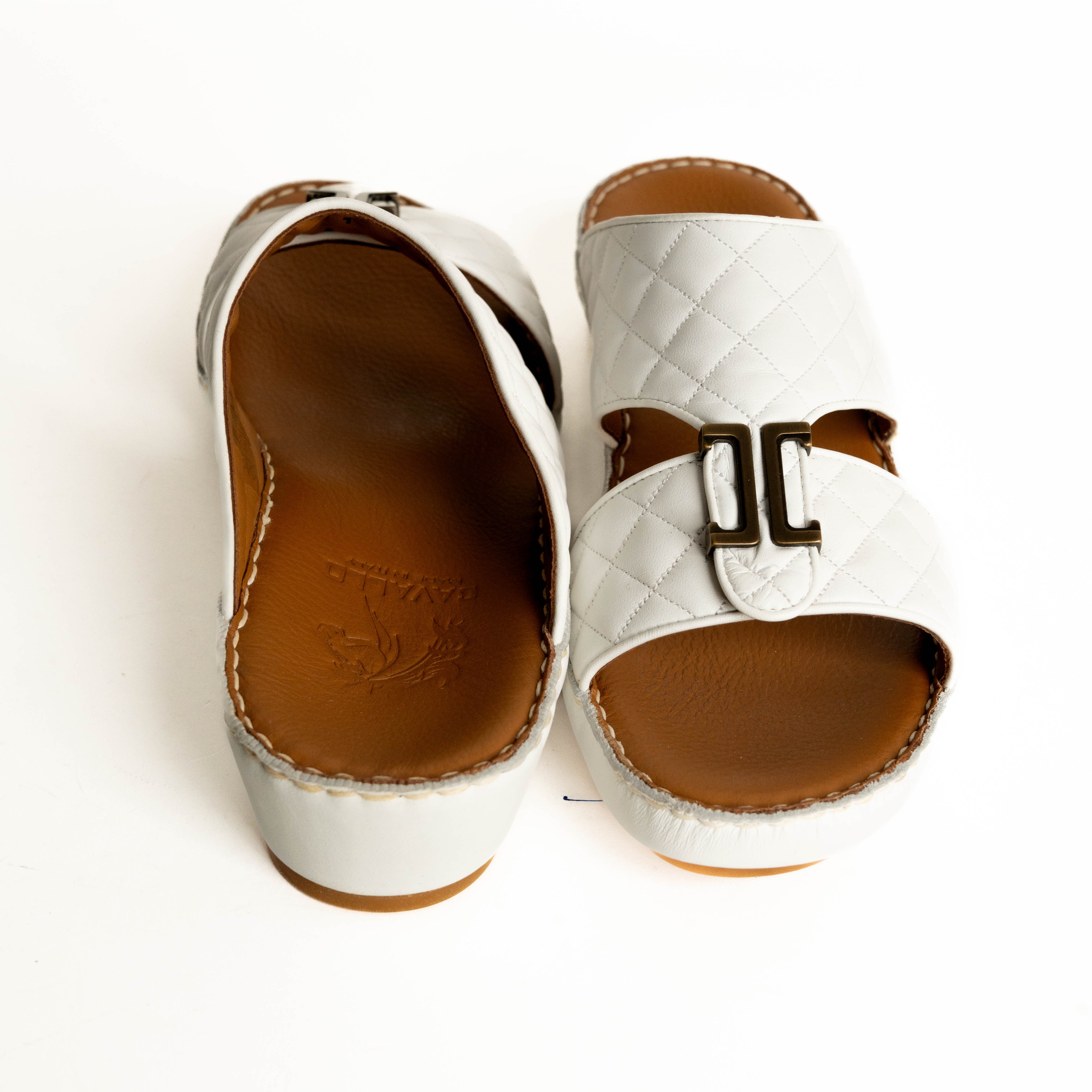 White sandal with brown buckle and sole on a white background
