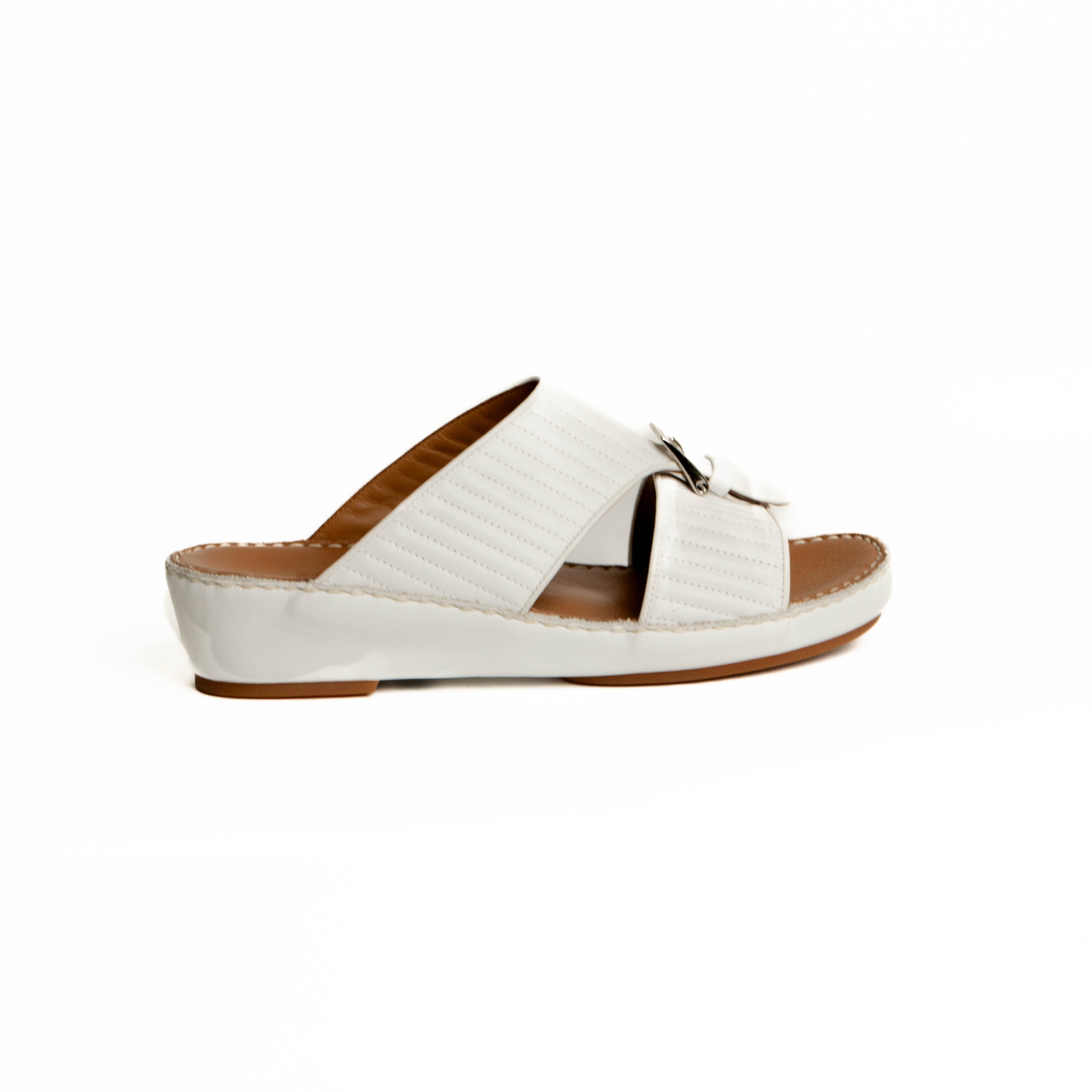 White sandal with a brown sole on a white background