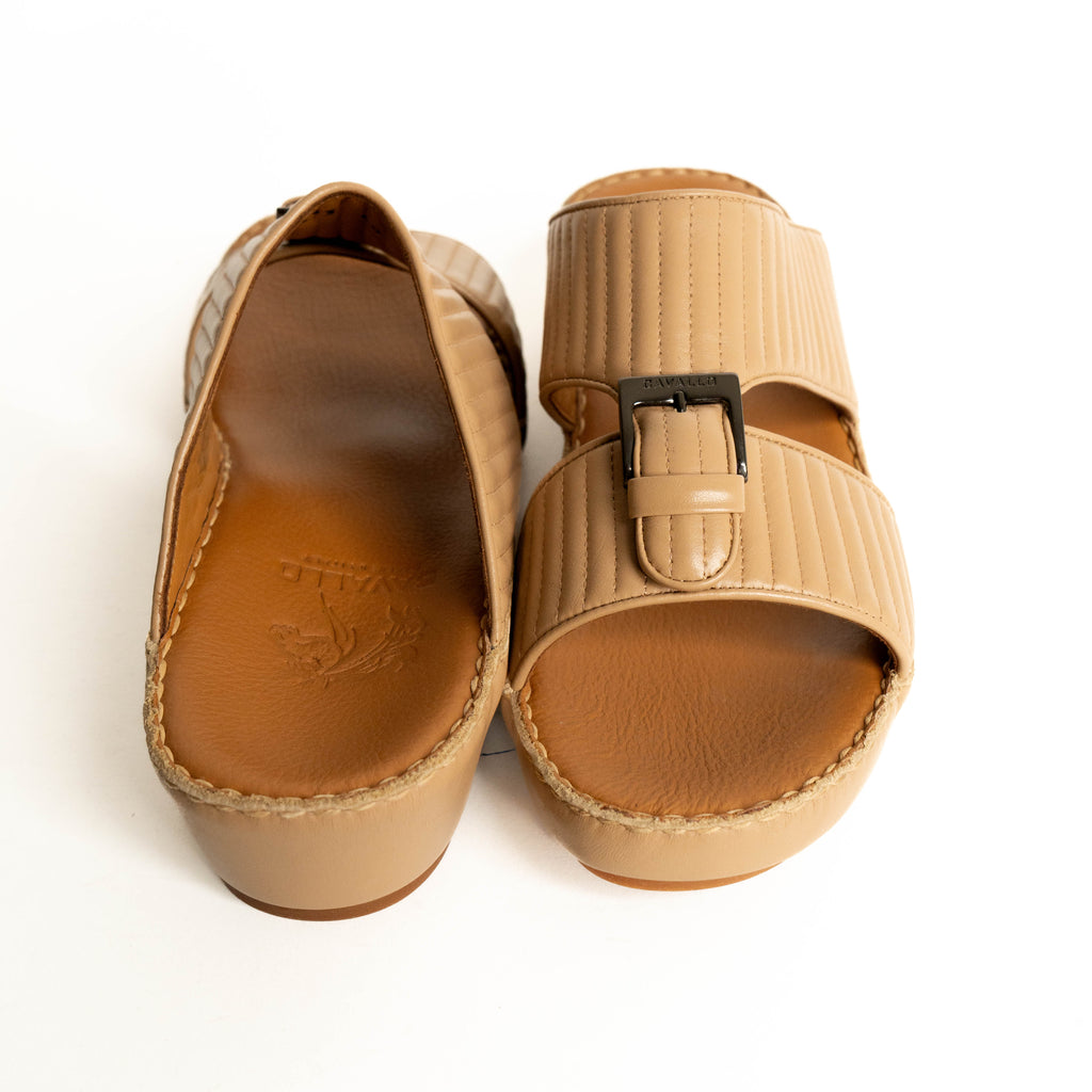 Pair of tan sandals with a buckle on a white background