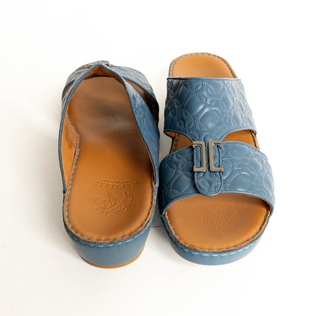 Pair of blue sandals with tan soles on a white background