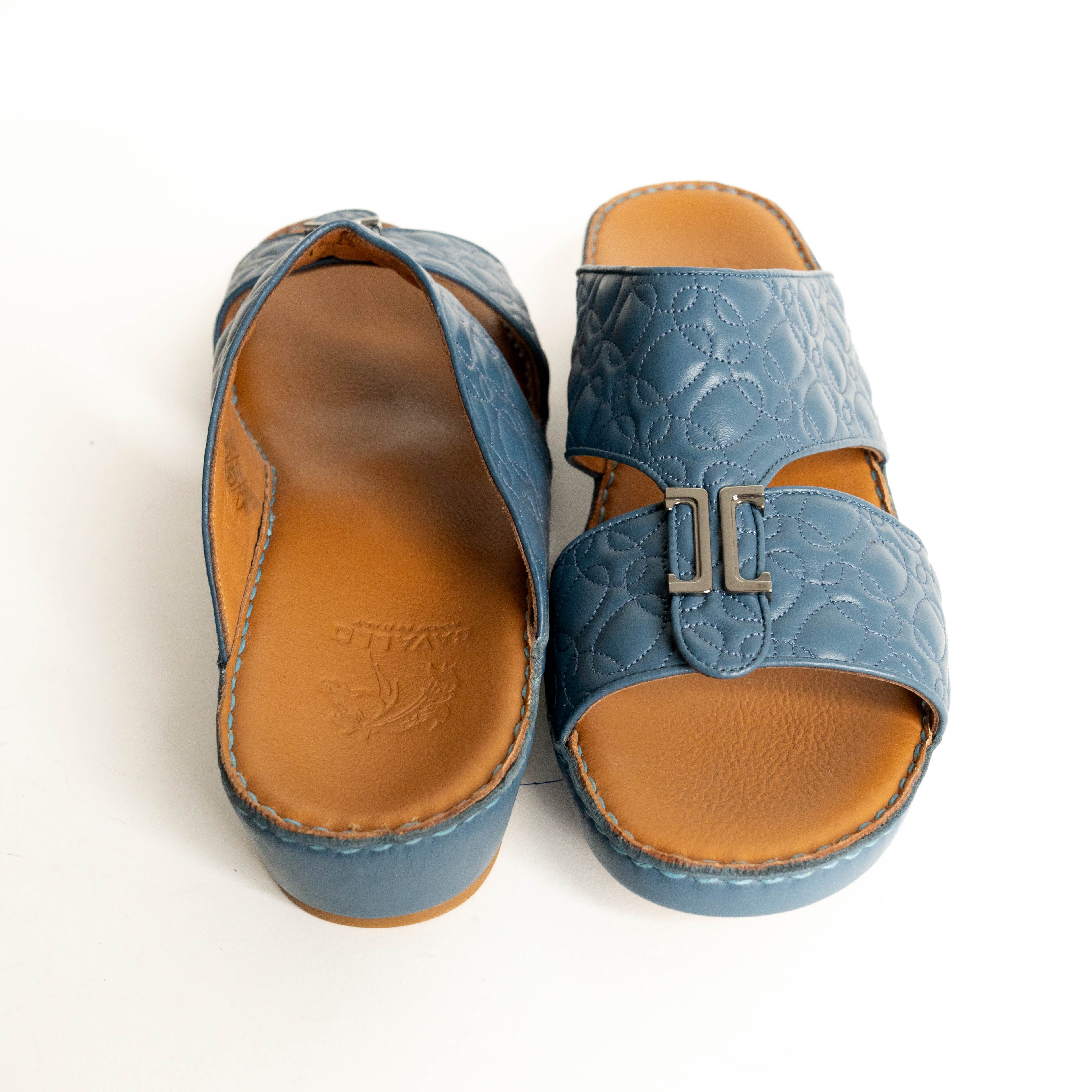 Pair of blue sandals with tan soles on a white background