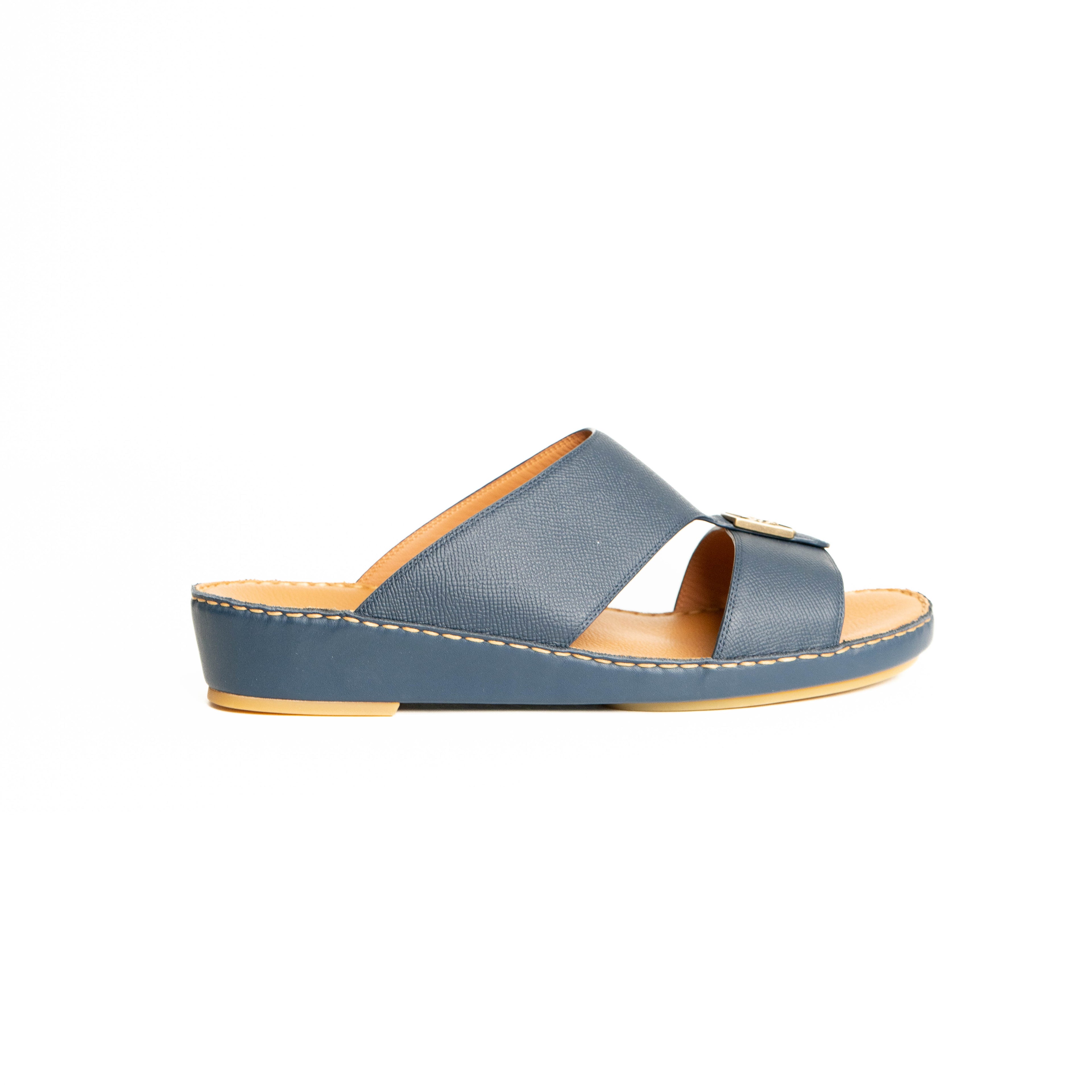 Blue sandal with a tan sole on a white background