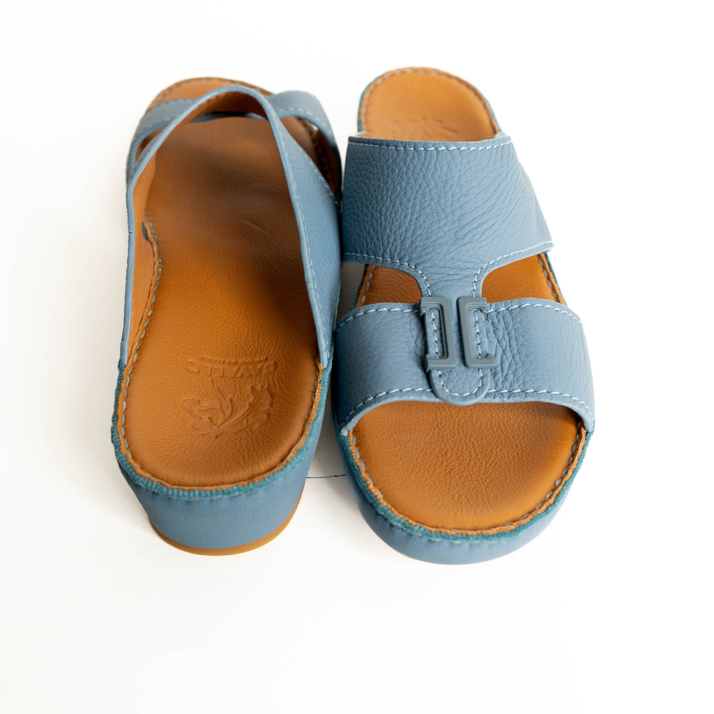Pair of blue sandals with brown soles on a white background