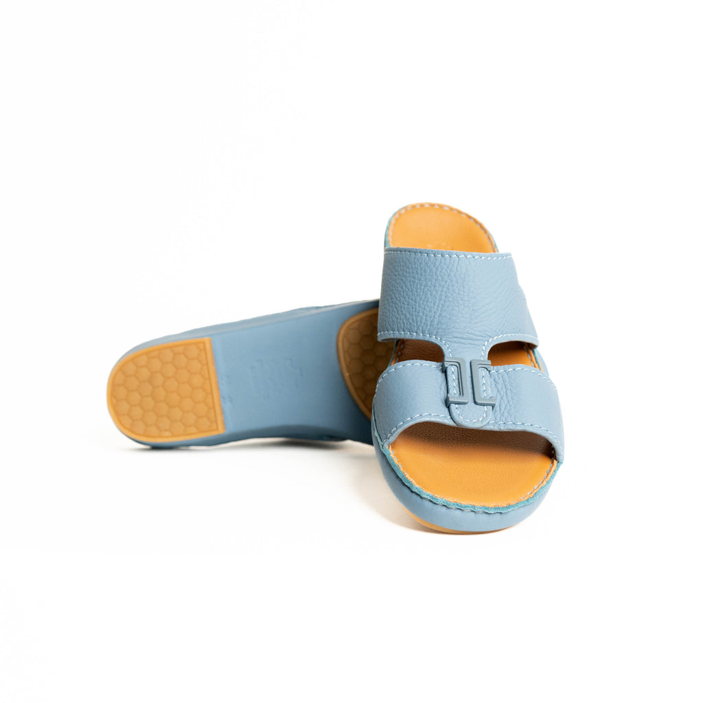 Light blue sandal with tan sole on a white background