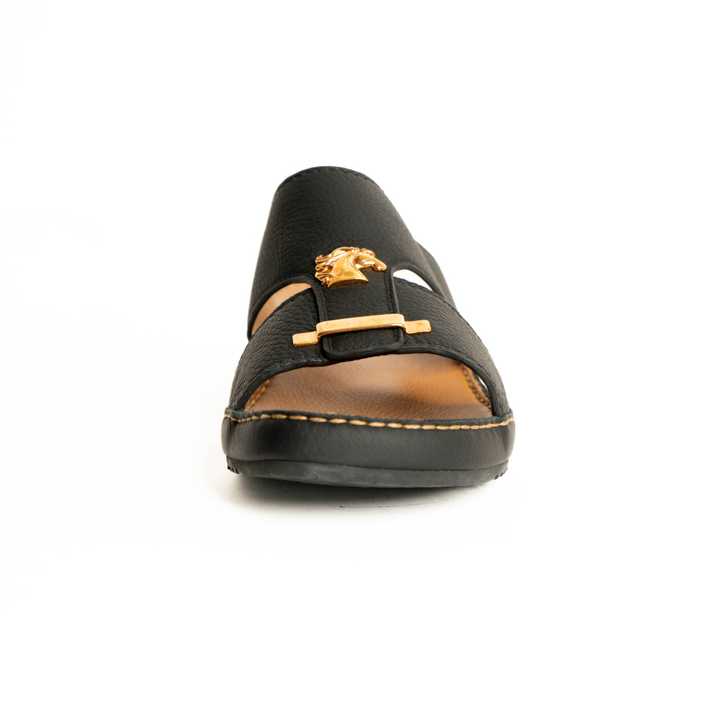 Black sandal with gold accents on a white background
