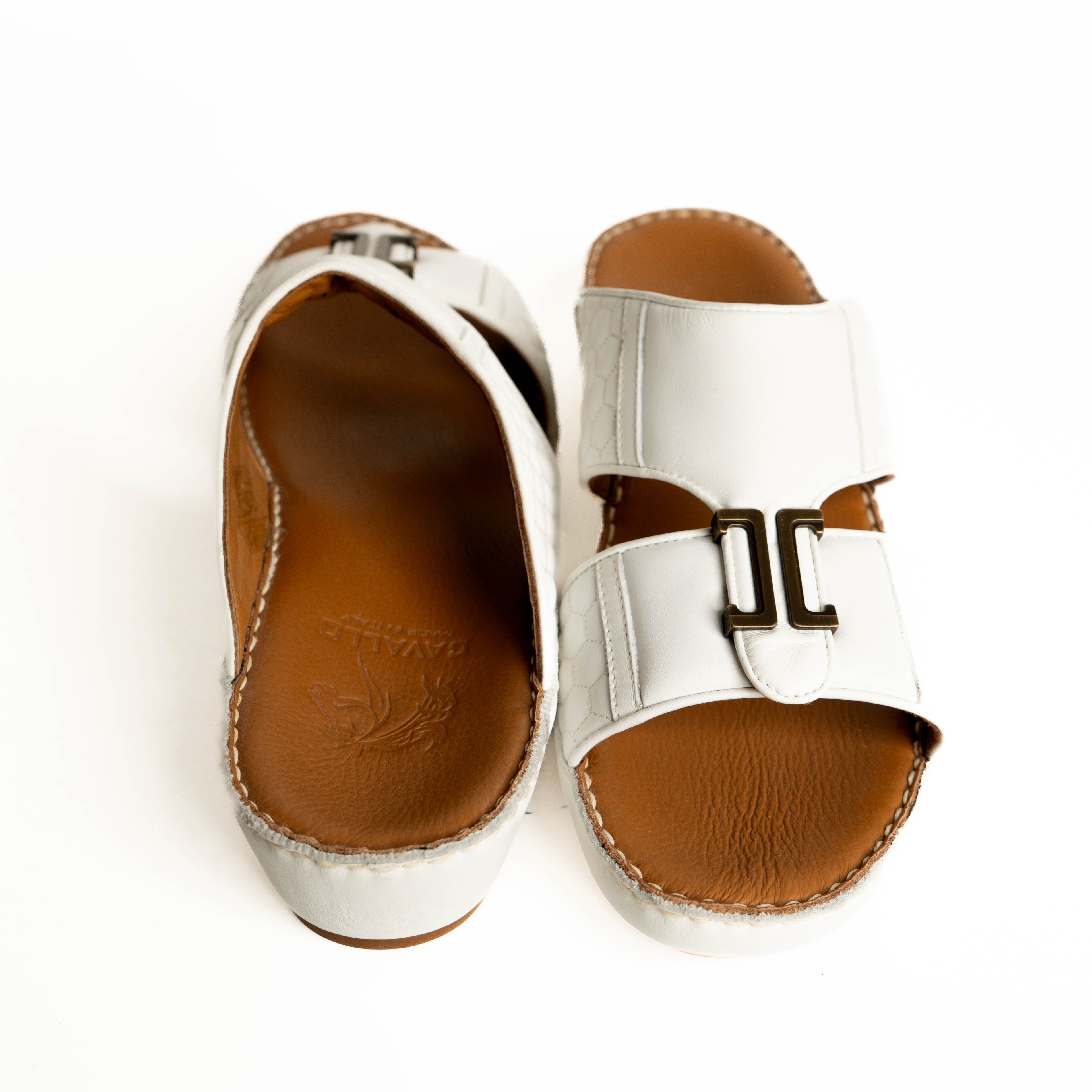 Pair of silver sandals with brown soles on a white background