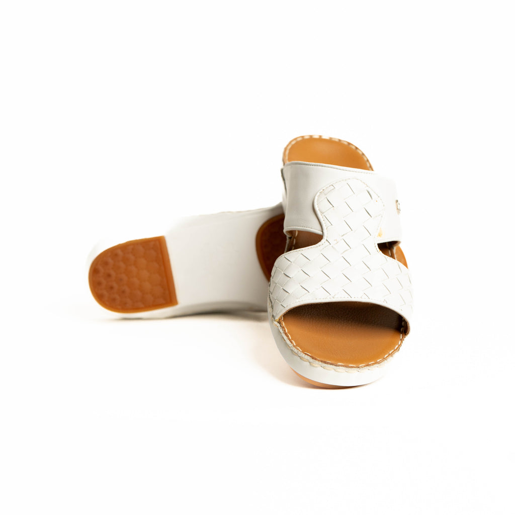 White open-toe sandals with brown soles on a white background