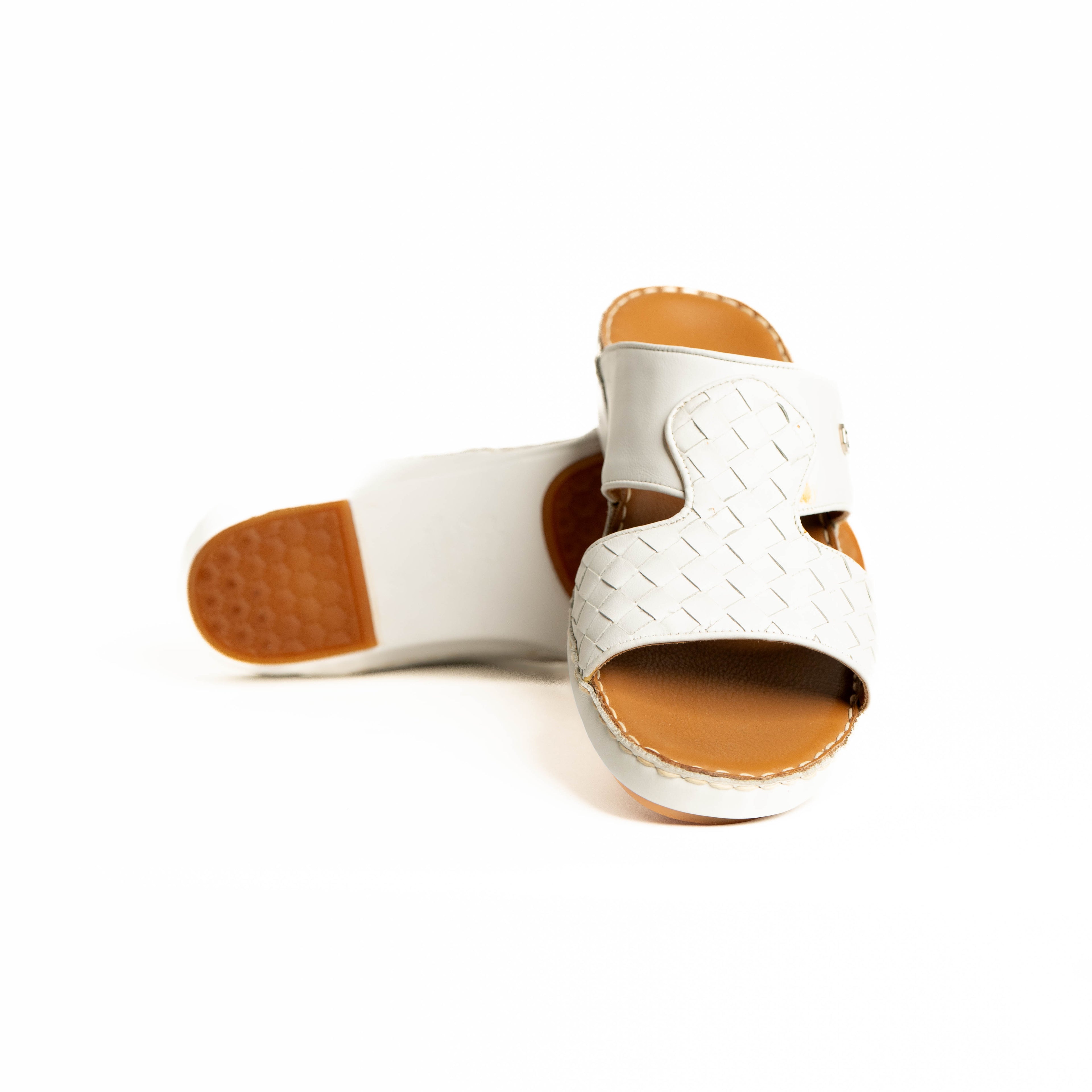White open-toe sandals with brown soles on a white background