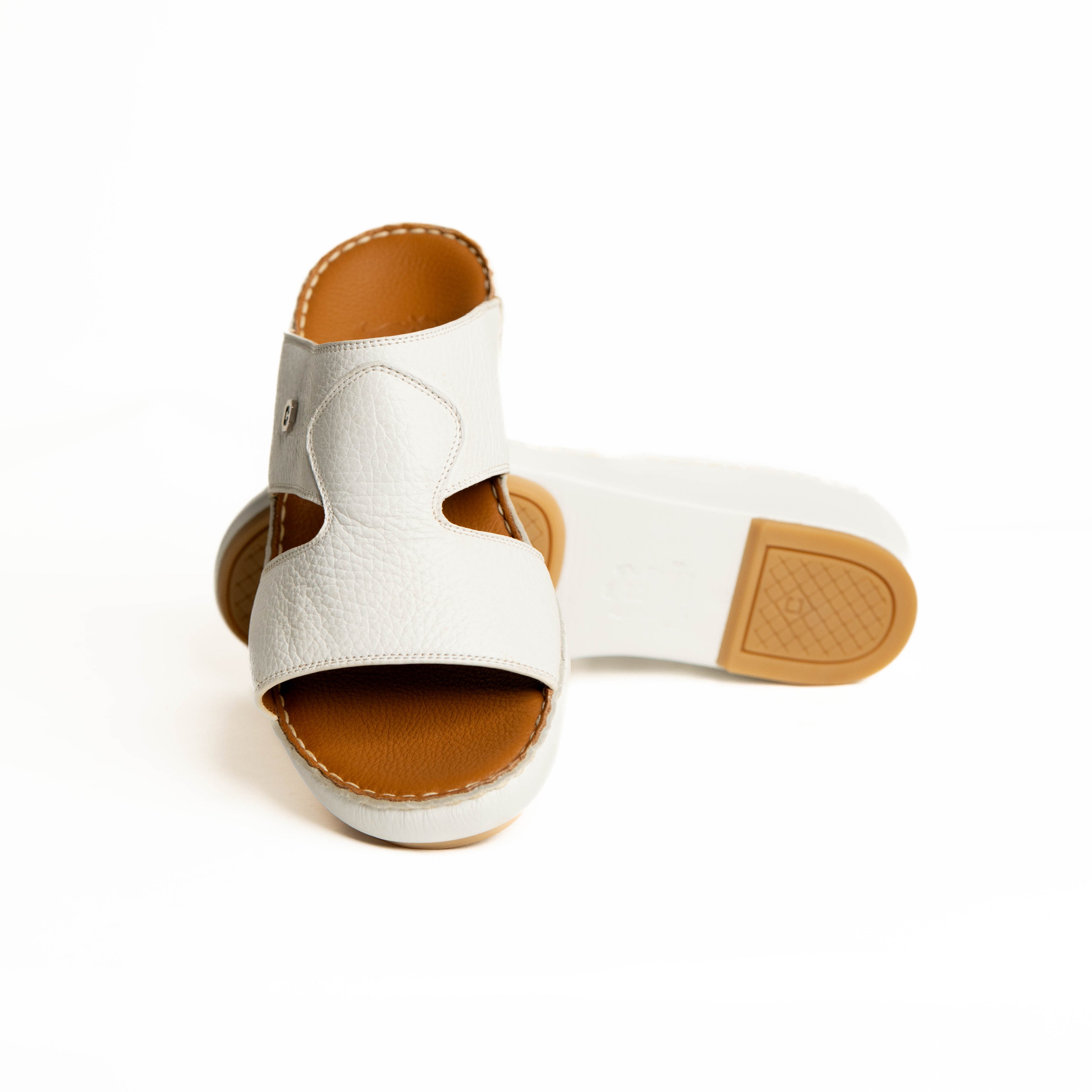 White sandal with brown sole on a white background