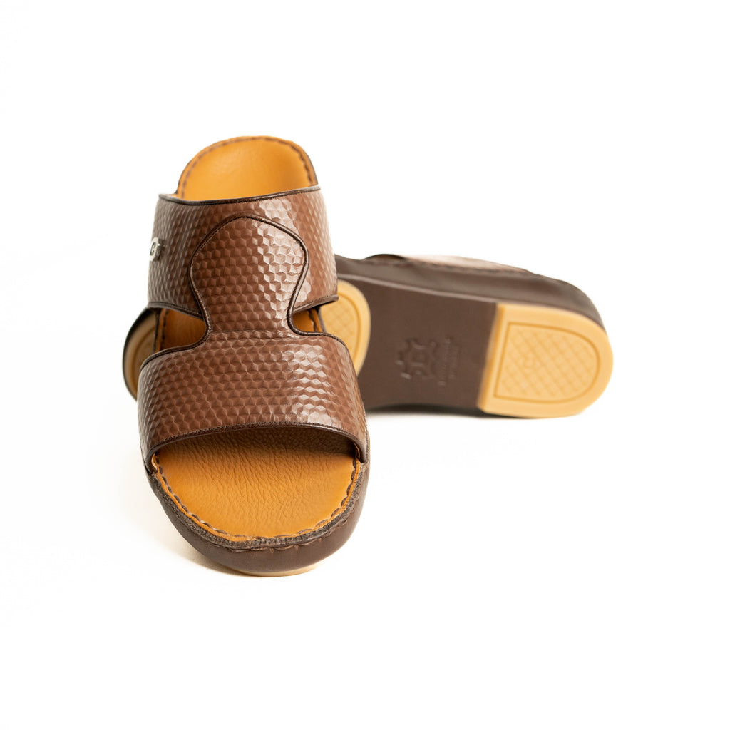 Brown sandal with textured strap design on a white background