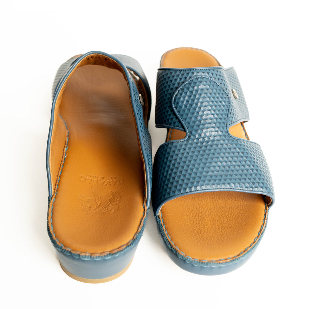 Pair of blue sandals with brown soles on a white background
