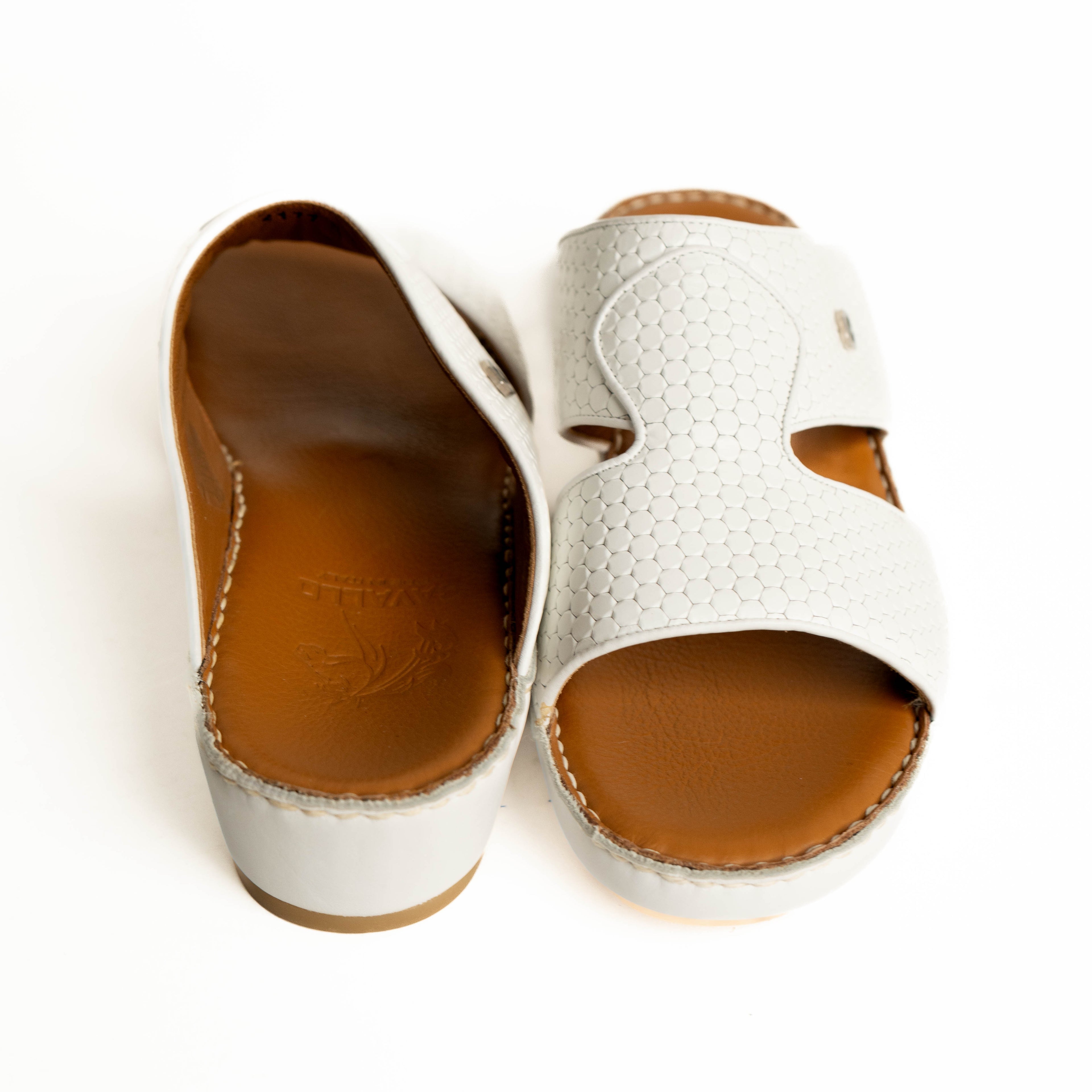 White sandals with brown soles on a white background