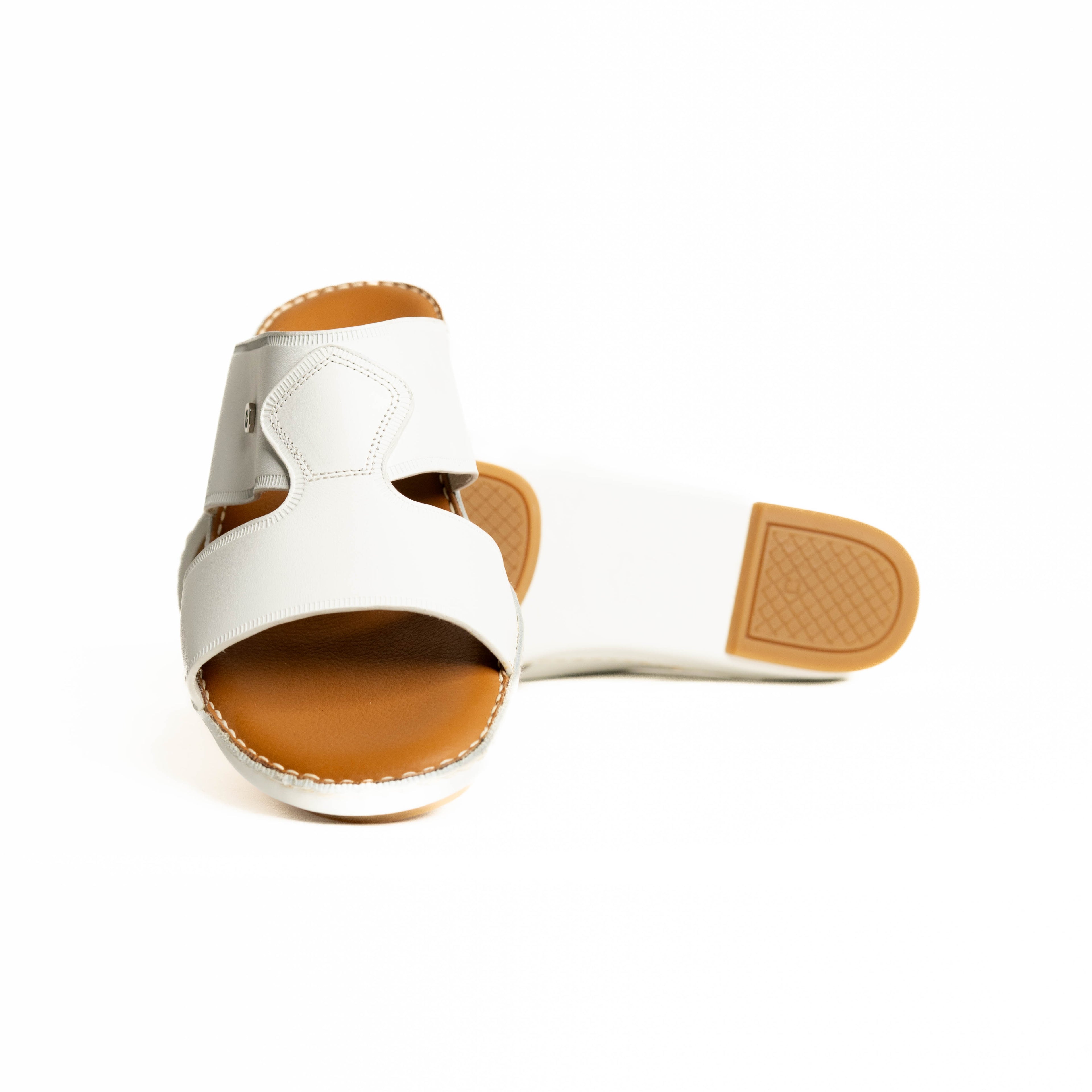 White sandal with brown sole on a white background