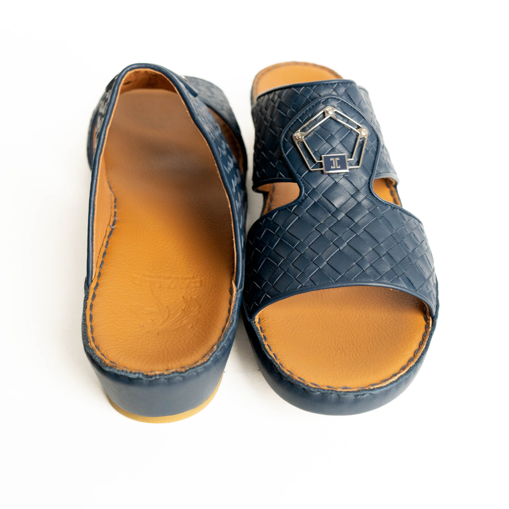 Pair of blue sandals with woven pattern and tan soles on a white background