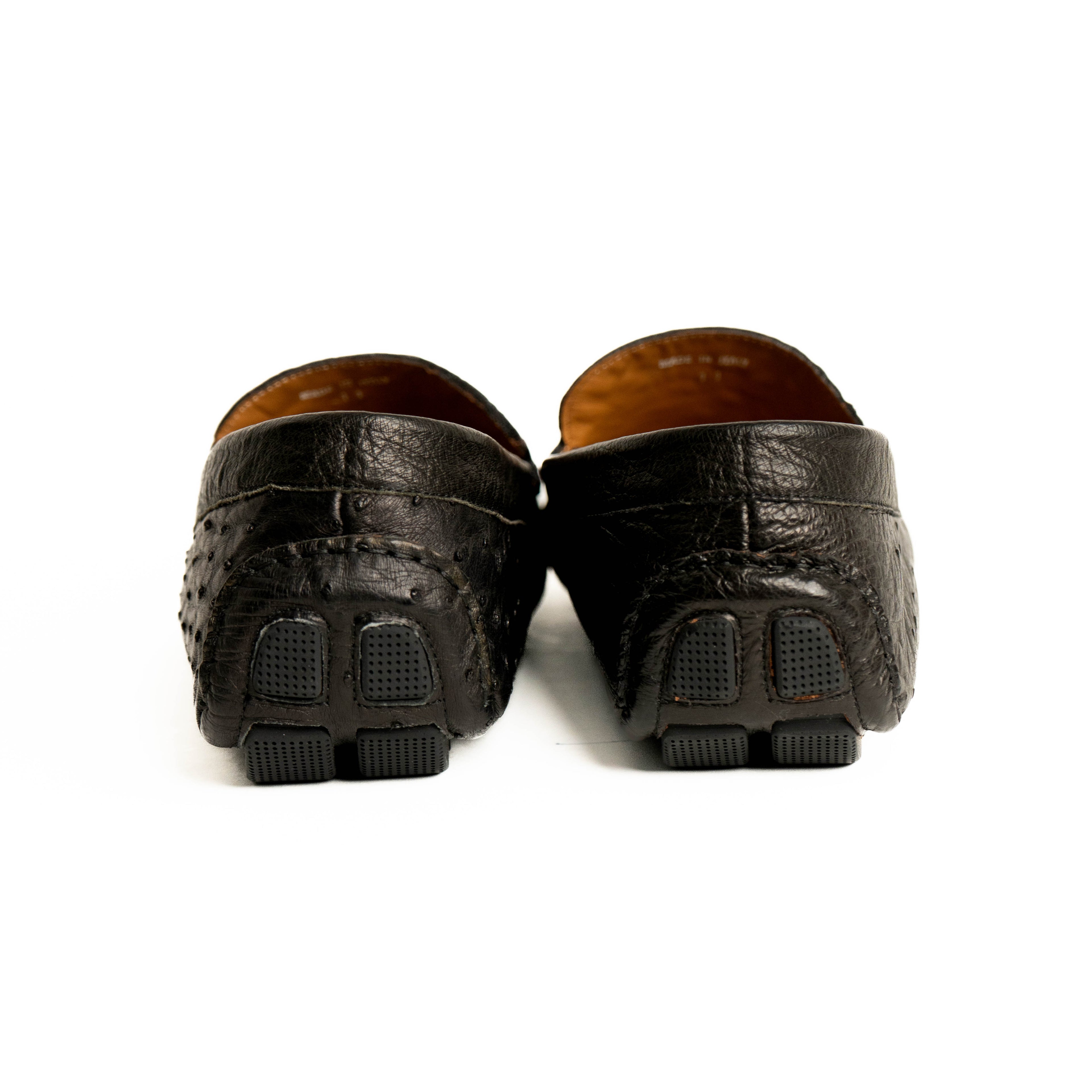 Pair of black leather loafers on a white background