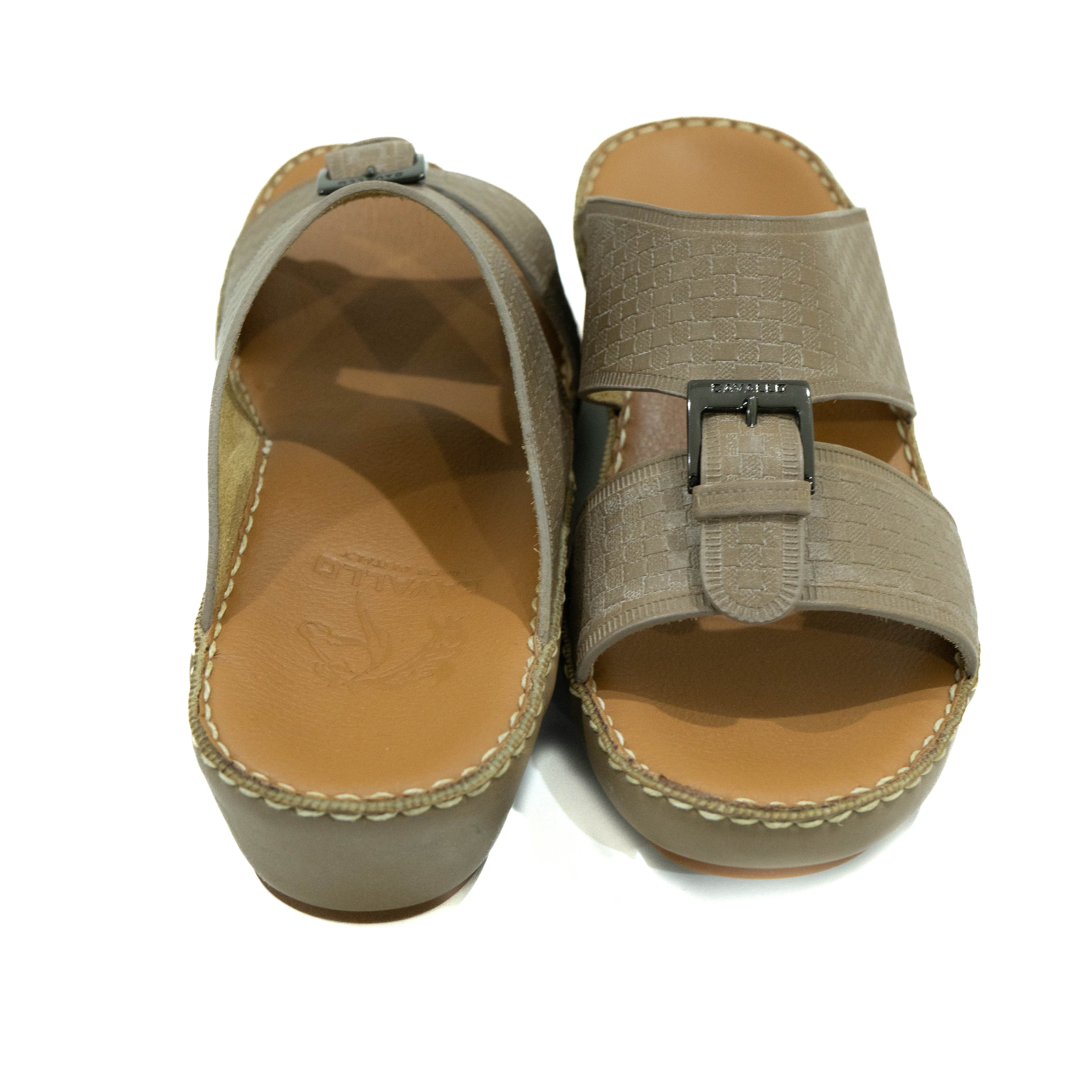 Pair of beige sandals with a buckle on a white background