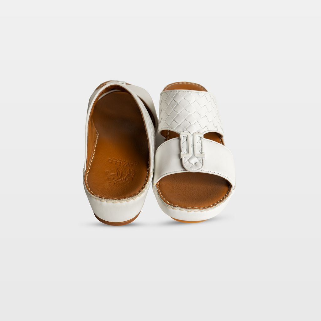 Pair of white sandals with brown soles on a light gray background
